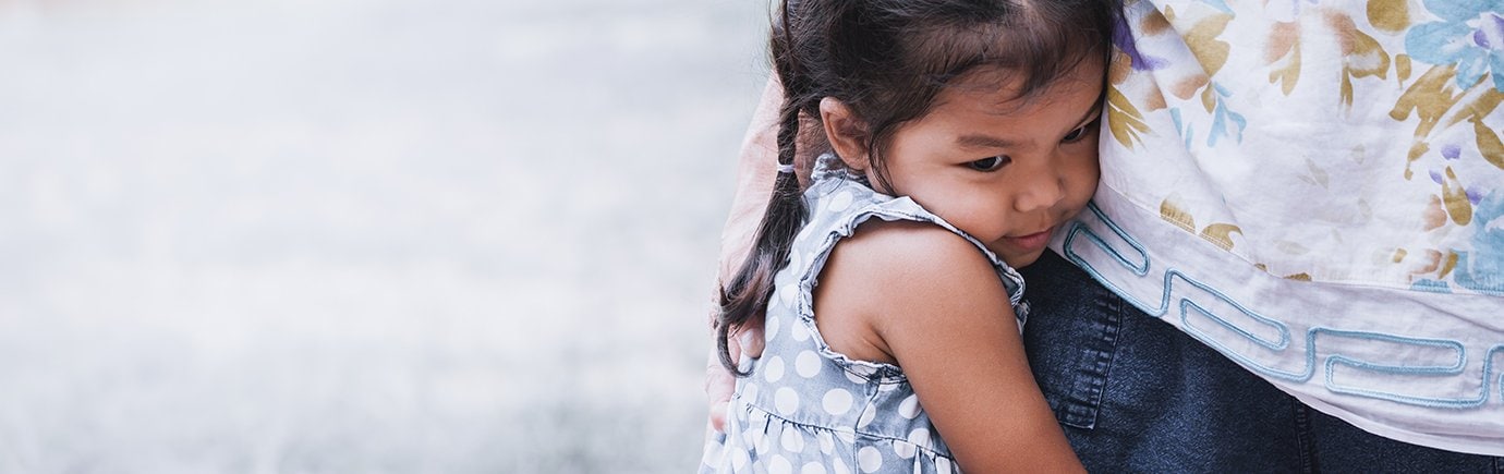 Anxious toddler clutching mom