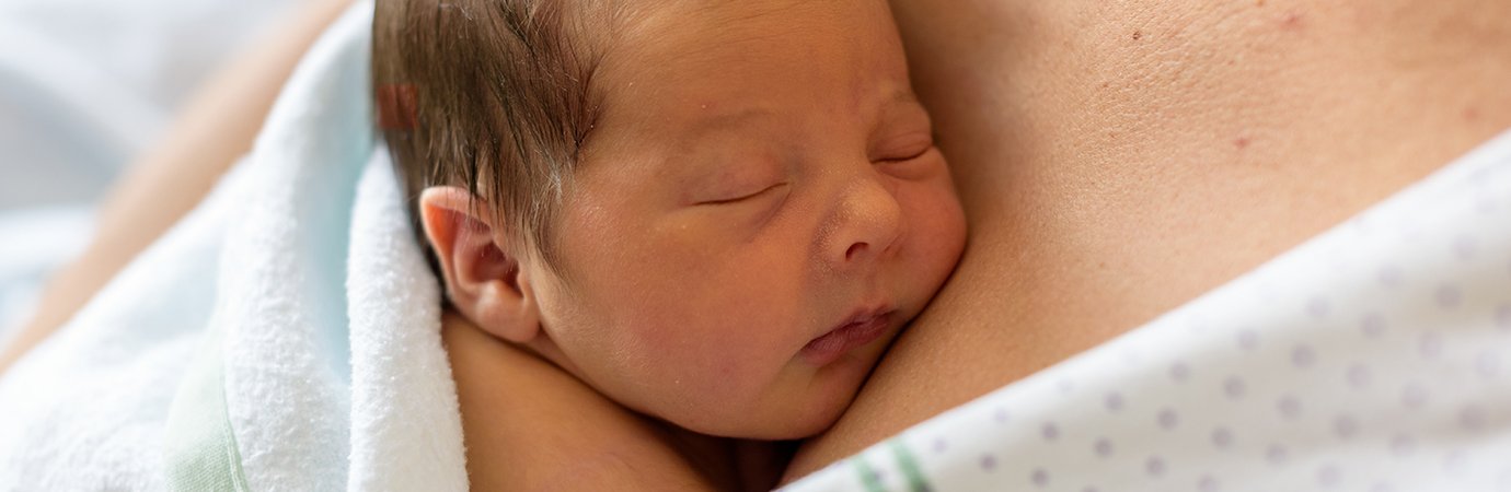 Newborn baby on mothers chest