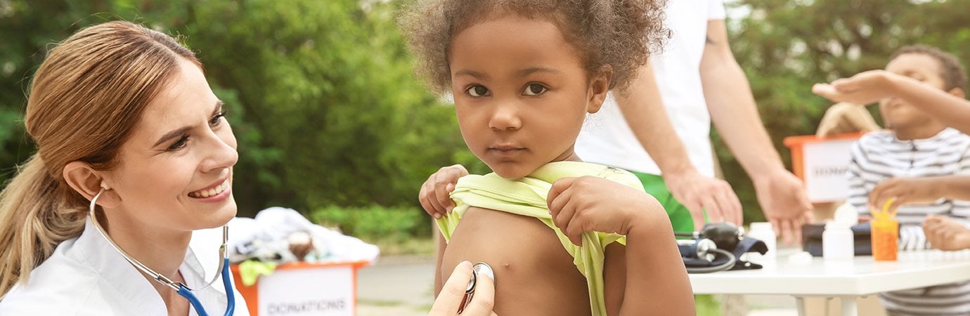 Doctor listening to child's heartbeat